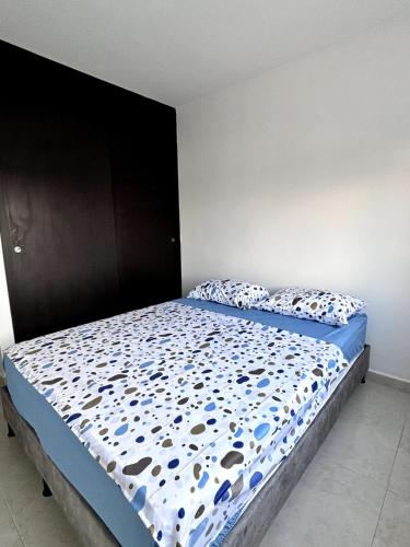 a bedroom with a bed with a blue comforter and pillows at Apartamento Bucaramanga in Bucaramanga