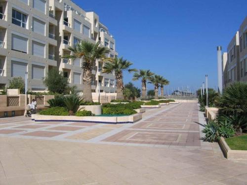 a street with palm trees and a building at Holiday luxury suite Herzliya marin see view in Herzliyya B