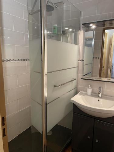 une salle de bain blanche avec un lavabo et une douche dans l'établissement St Cyprien Maison 4p avec grande terrasse et jardin clos, à Saint-Cyprien
