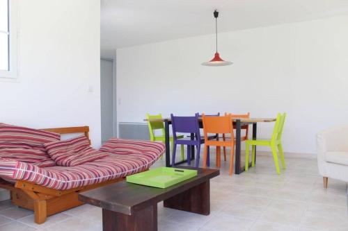 un salon avec un canapé et une table avec des chaises dans l'établissement Maison 4 pièces- 6 couchages- Saint-Denis d'Oléron SDO000-070, à Saint-Denis-dʼOléron