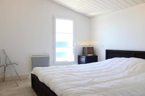 une chambre avec un grand lit blanc avec une fenêtre dans l'établissement Maison 4 pièces- 6 couchages- Saint-Denis d'Oléron SDO000-070, à Saint-Denis-dʼOléron