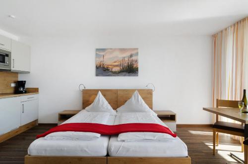 a bedroom with a bed with a red and white blanket at Gästehaus D i c k r e i t e r in Immenstaad am Bodensee