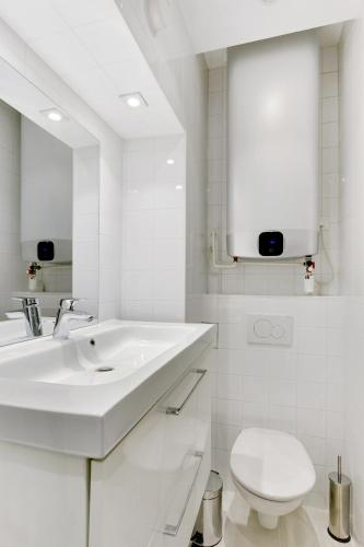 une salle de bain blanche avec un lavabo et des toilettes dans l'établissement Pick A Flat's Apartment in Batignolles - Passage Cardinet, à Paris