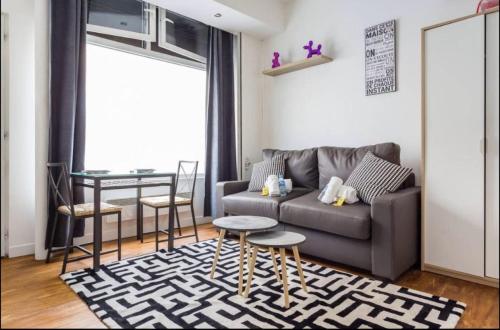 un salon avec un canapé et une table dans l'établissement 2 Cozy studio Père Lachaise Nation, à Paris