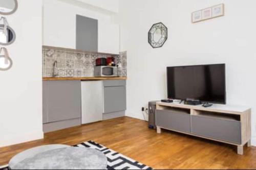 Il comprend un salon avec une télévision à écran plat et une cuisine. dans l'établissement 2 Cozy studio Père Lachaise Nation, à Paris