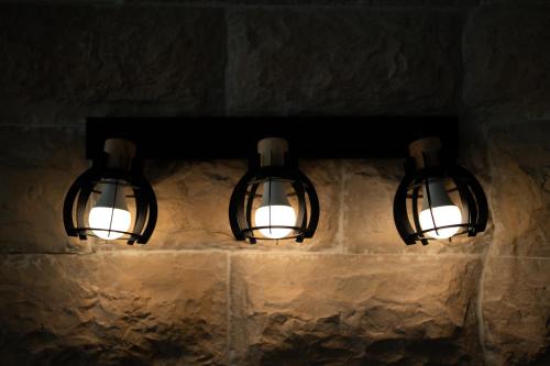 a pair of lights hanging on a stone wall at Villa Yuka- Luxurious Villa in Eilat