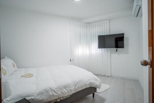 a bedroom with a bed with a tv on the wall at Villa Yuka- Luxurious Villa in Eilat