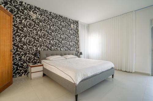 a bedroom with a bed and a black and white wall at Villa Yuka- Luxurious Villa in Eilat