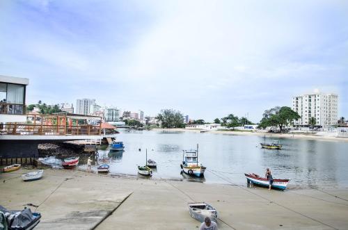 a group of boats are docked in a river at MAIOR NOTA - 2 Quartos com AR CONDICIONADOS SPLIT, Air Fryer, Wi-Fi, Disney Plus, Star Plus, HBO Max, Guarda Sol, Cadeiras de Praia, Caixa Térmica, Churrasqueira, Rede para Descanso e Chuveirão - 8 pessoas - CONFORTO Máximo - Melhor Localização!! in Guarapari