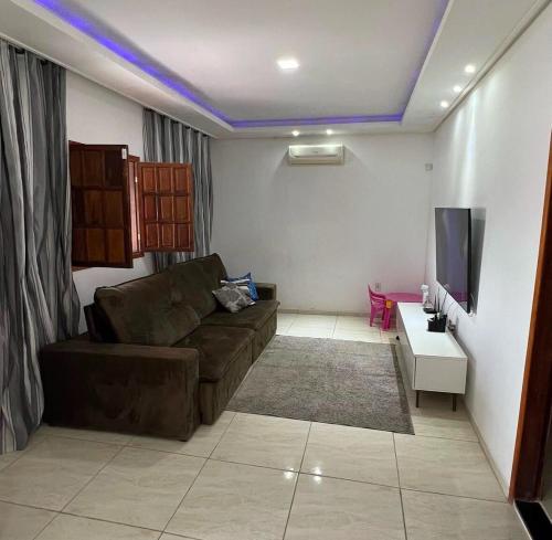 een woonkamer met een bank en een tv bij Praia Grande House in Fundão