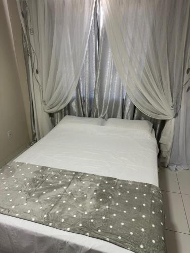 a bedroom with a bed with a canopy and curtains at Águas cristalinas 02 in Cabo Frio