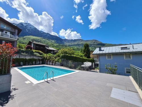 a swimming pool in a yard with mountains in the background at Agata House in Colico