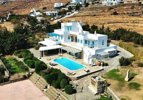 an aerial view of a large white house with a swimming pool at Villa Marble Tinos in Agios Fokas