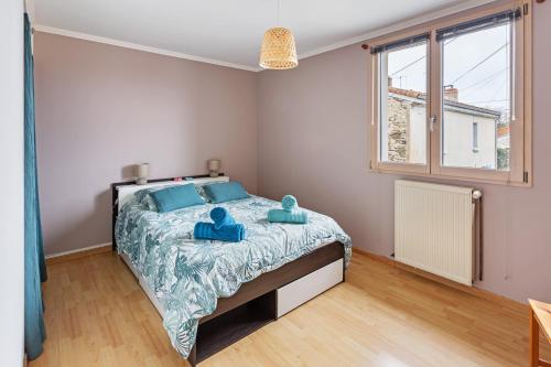 une chambre avec un lit avec deux serviettes bleues dessus dans l'établissement La Margotte, Maison Charmante et Spacieuse, à Vertou