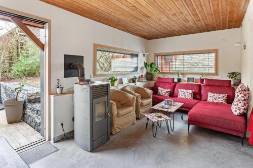 un salon avec un canapé rouge et une table dans l'établissement La Margotte, Maison Charmante et Spacieuse, à Vertou