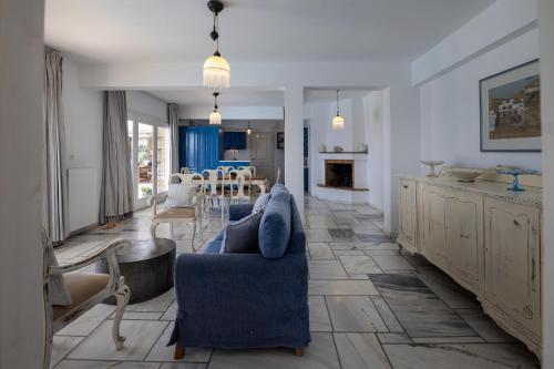 a living room with a blue couch and a table at Villa Marble Tinos in Agios Fokas