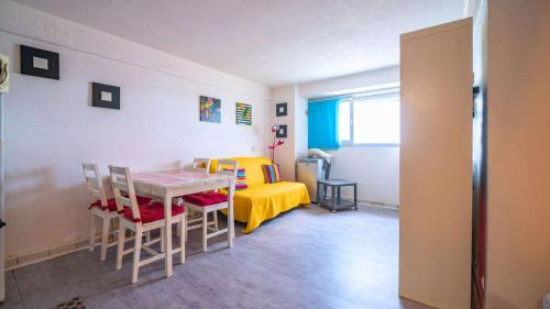 une pièce avec une table, des chaises et un lit dans l'établissement T2- pied dans l'eau- clim, au Lavandou