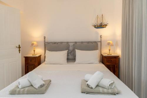a bedroom with a large bed with two towels at Villa Marble Tinos in Agios Fokas