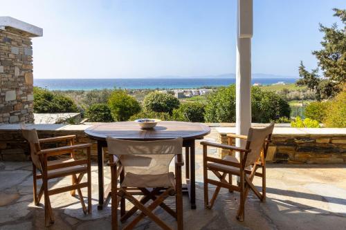 a table and chairs on a patio with a view at Villa Marble Tinos in Agios Fokas