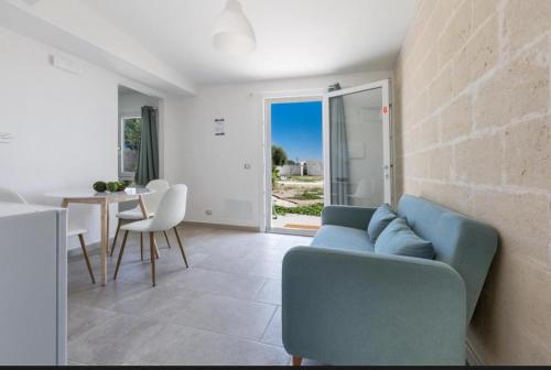 a living room with a blue couch and a table at Villa Lea in Pulsano