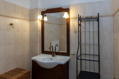 a bathroom with a sink and a mirror at Villa Marble Tinos in Agios Fokas