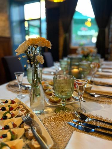 a long table with plates of food and flowers on it at Kamienica Boutique ApartHotel in Białystok