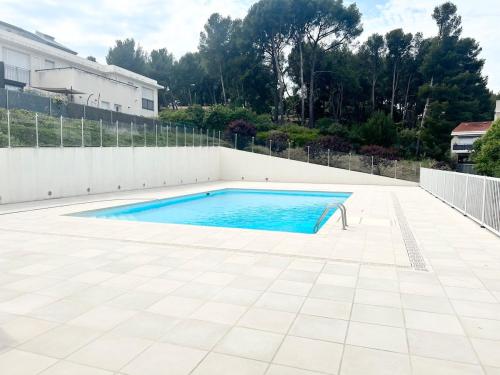 - une piscine avec du carrelage et une clôture blanche dans l'établissement CHEZ MONNA confort , résidence avec piscine, à La Ciotat