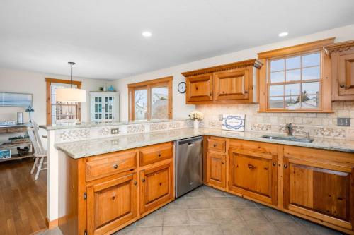 a kitchen with wooden cabinets and a stainless steel dishwasher at 57 Wood Avenue Sandwich - - Cape Cod in Sandwich