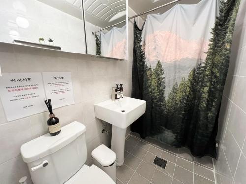 a bathroom with a sink and a toilet and a shower curtain at JAJA Haenggung, SuwonㅣNext to Hwaseong FortressㅣCozy Korean VibeㅣComfortable & Well-keptㅣUp to 8 guestsㅣFree Parkingㅣ2-night minimumㅣLoved by many guests in Suwon