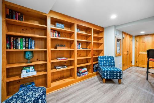 a living room with book shelves and two chairs at 57 Wood Avenue Sandwich - - Cape Cod in Sandwich