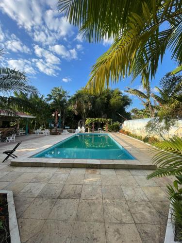 a swimming pool in a resort with palm trees at Acomodações Hilton 100 in Ipueiras
