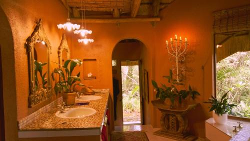 a bathroom with two sinks and a large mirror at Timamoon Lodge in Hazyview