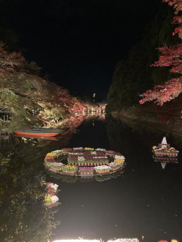 an island in the water at night with two boats at 自然体験と石窯のある古民家民泊アジールAsyl in Hirosaki