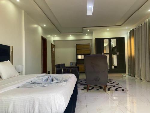 a bedroom with a bed and a chair in it at Bi-Hotel 1 in Dakar