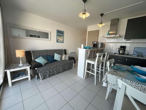 un salon avec un canapé et une cuisine dans l'établissement Appartement 2 pièces avec balcon et parking privé - FR-1-224B-71, à Noirmoutier-en-l'lle