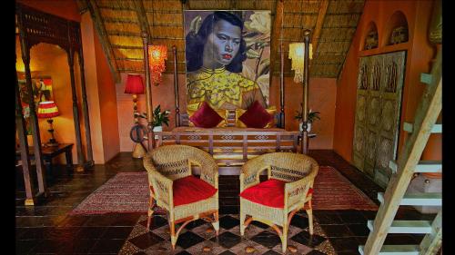 a room with a table and two chairs and a painting at Timamoon Lodge in Hazyview