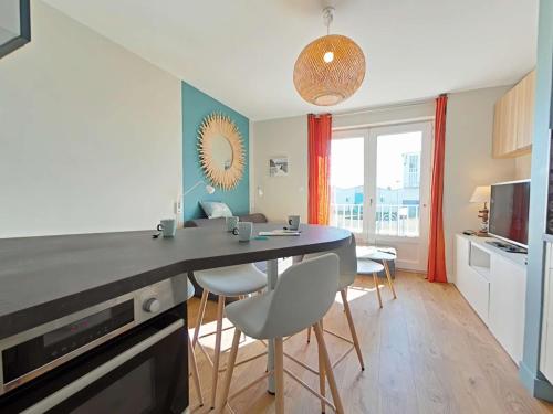 une cuisine avec une table et des chaises dans une pièce dans l'établissement Appartement rénové, 4 couchages, proche commerces et plage, avec jardin et services inclus. - FR-1-224-782, à Saint-Gilles-Croix-de-Vie
