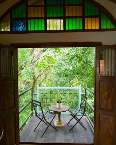 a table and chairs on a porch with a stained glass window at Timamoon Lodge in Hazyview