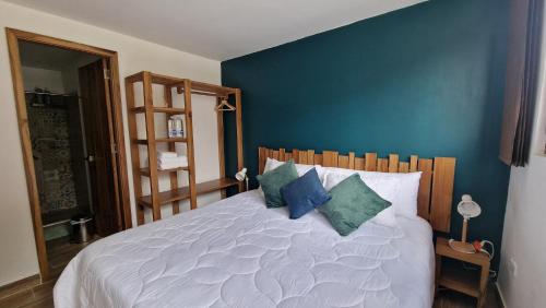 a bedroom with a large white bed with blue walls at Hotel La Caracola Salento in Salento
