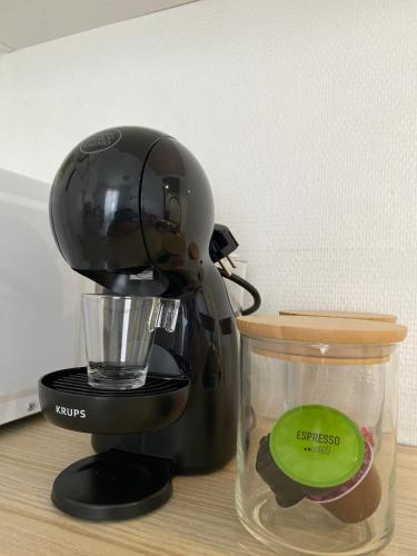 un mélangeur noir assis sur un comptoir avec un conteneur dans l'établissement BEAU studio proximité GARE et CENTRE VILLE, à Strasbourg