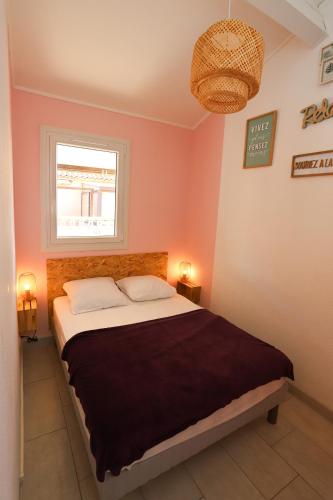 une chambre avec un lit et une fenêtre dans l'établissement St Cyprien moderne maison T2 mezzanine proche plage, à Saint-Cyprien