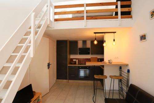 une cuisine et une salle à manger avec une mezzanine dans l'établissement St Cyprien moderne maison T2 mezzanine proche plage, à Saint-Cyprien
