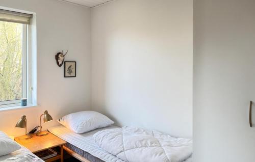 a bedroom with a bed and a desk and a window at Lovely Home In Samsø With Kitchen in Tanderup