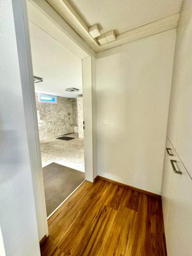 an empty room with a wooden floor and white walls at Thunersee Retreat in Thun