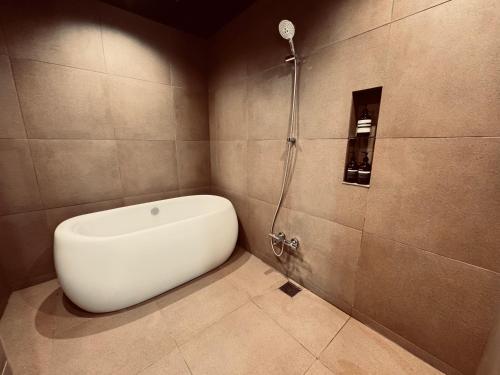 a bathroom with a shower with a white bidet at THE KAKU NARA Gin in Nara