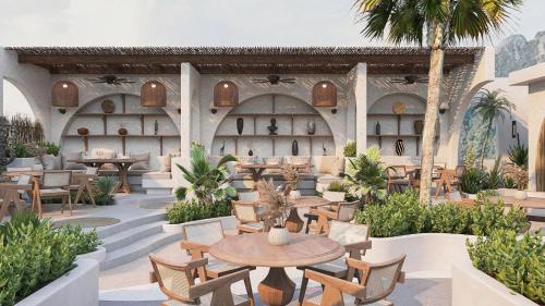 an outdoor patio with tables and chairs and palm trees at Sunrise Mountain View Resort in Vang Vieng