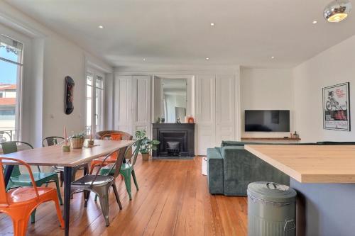 un salon avec une table et des chaises et une cheminée dans l'établissement Escape and Charm in La Croix-Rousse Stunning One-Bedroom Apartment for an, à Lyon