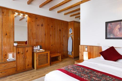 a bedroom with wooden walls and a bed and a mirror at Hotel Country Villa in Nagarkot