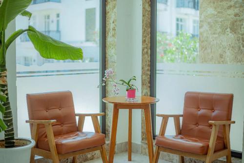 two chairs and a table in a room with a table at Sunrise Valley Dalat Hotel in Da Lat