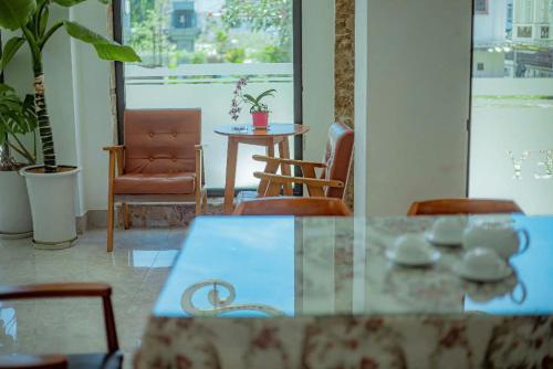 a dining room with a table and chairs and a window at Sunrise Valley Dalat Hotel in Da Lat